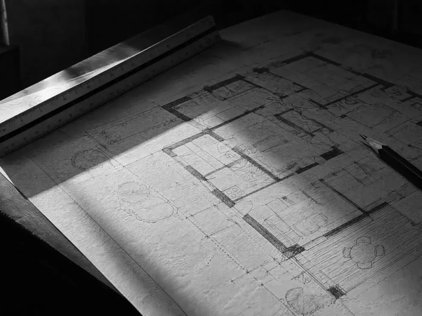 Handgezeichneter Grundriss mit Stahl-Lineal und Bleistift auf einem Zeichentisch